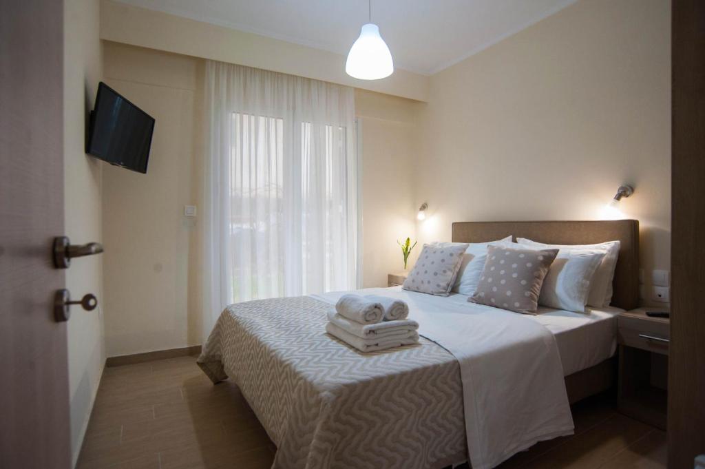 una camera da letto con un letto e asciugamani su un tavolo di Vanessa's Rooms & Apartments a Kanali