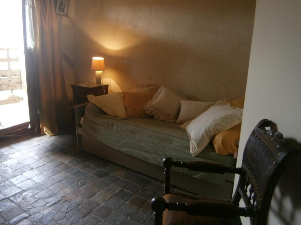 a couch with pillows in a room with a window at Chateau de Chémery in Chémery