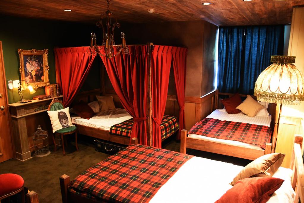 福岡市にあるExpected Innのベッドルーム1室(ベッド2台、赤いカーテン付)