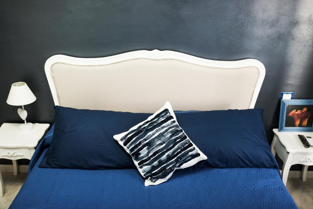 a bedroom with a blue bed with a white headboard at INFORMIS B&B in Capua