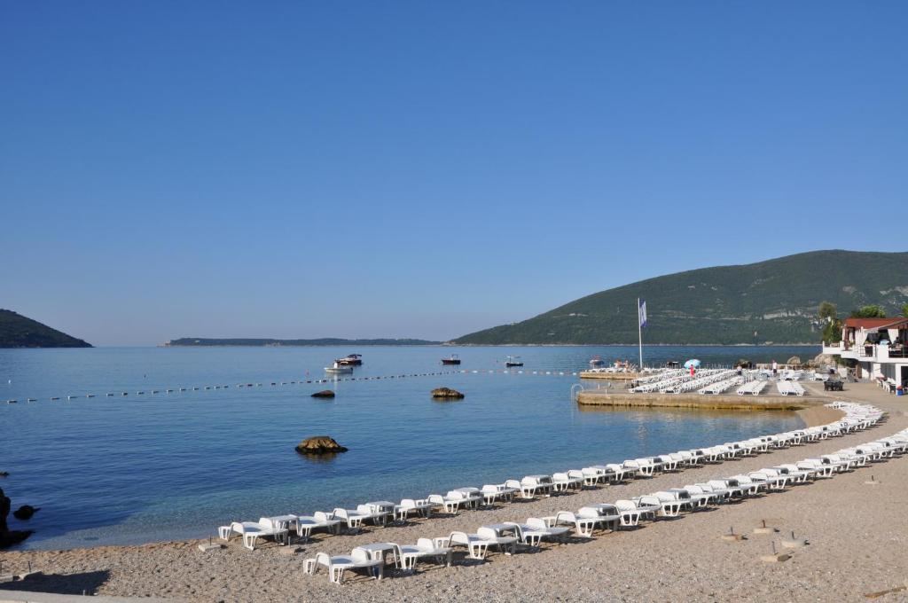 a row of boats sitting on top of a sandy beach at Hotel Perla in Herceg-Novi