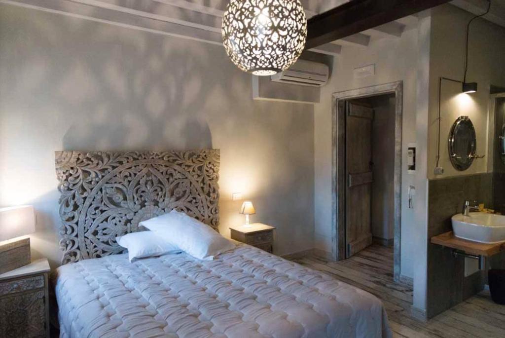 CavriagoにあるROSSOdiVinoのベッドルーム1室(ベッド1台、シンク、シャンデリア付)