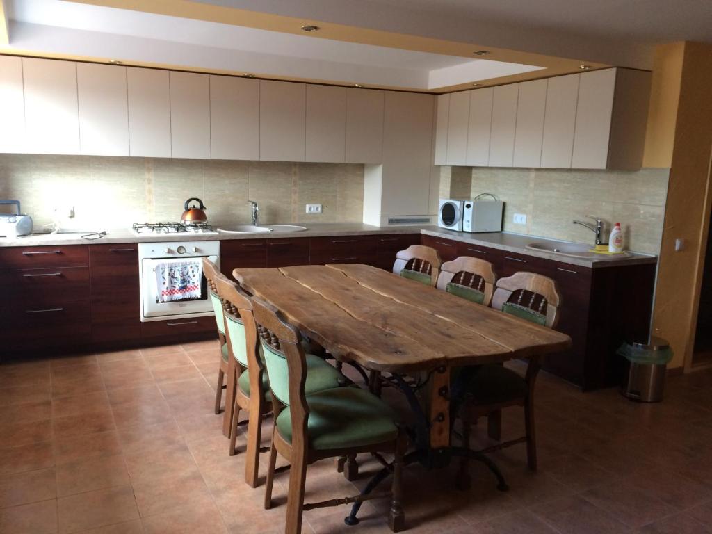 a large kitchen with a wooden table and chairs at Svečių namai in Ryškėnai