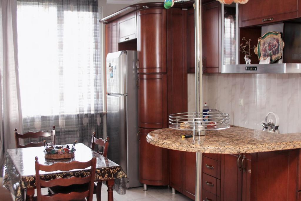 cocina con nevera y mesa con sillas en Apartment Rustaveli 57 en Batumi