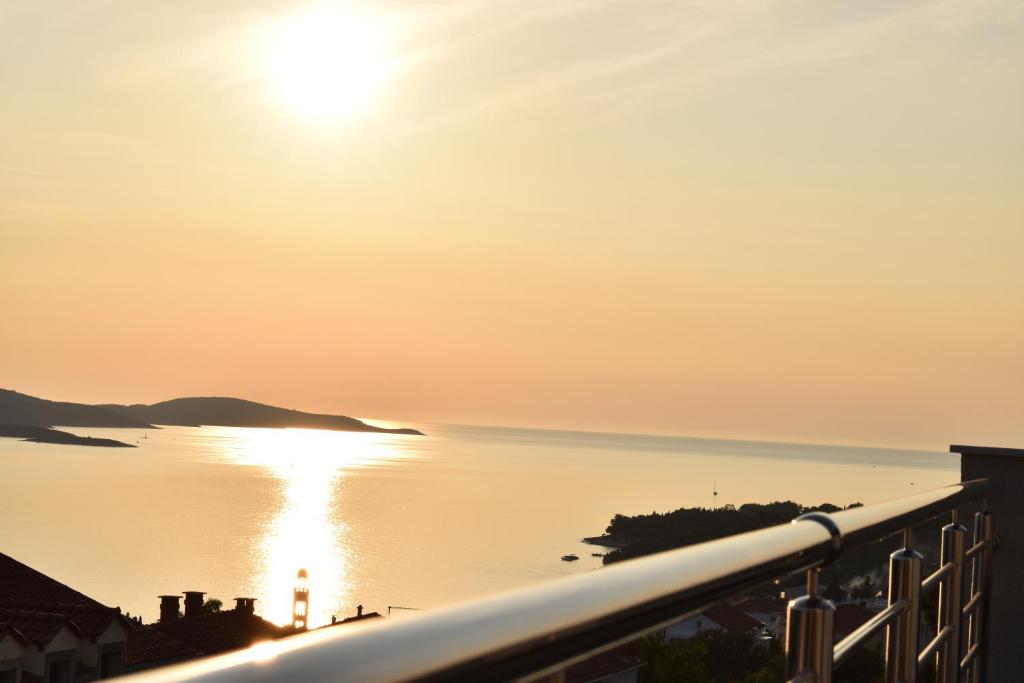a view of the ocean at sunset from a balcony at Apartments Pera in Hvar