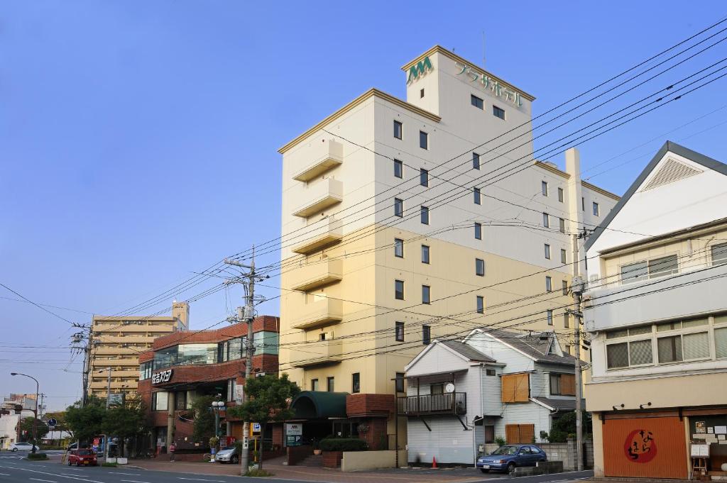 a tall white building on a city street at Fukuyama Plaza Hotel in Fukuyama