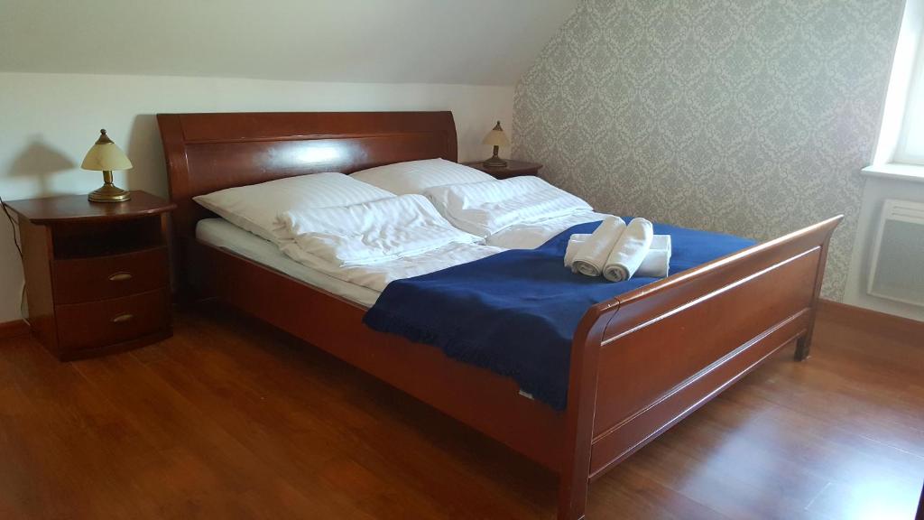 1 cama con manta azul y almohadas blancas en Leba - Apartament z tarasem przy kanale portowym - widok na statki en Łeba