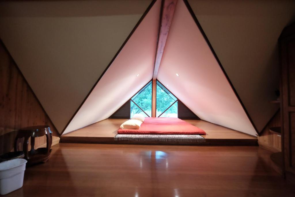 Ce lit se trouve dans une chambre avec tente triangulaire. dans l'établissement Pa-Rita Country Home, à Mu Si