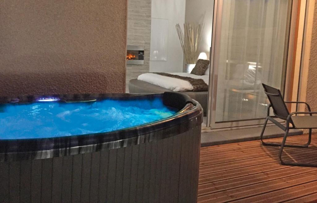 - un bain à remous dans une chambre avec un lit et une chaise dans l'établissement LOFT SPA - Côté château., à Carcassonne