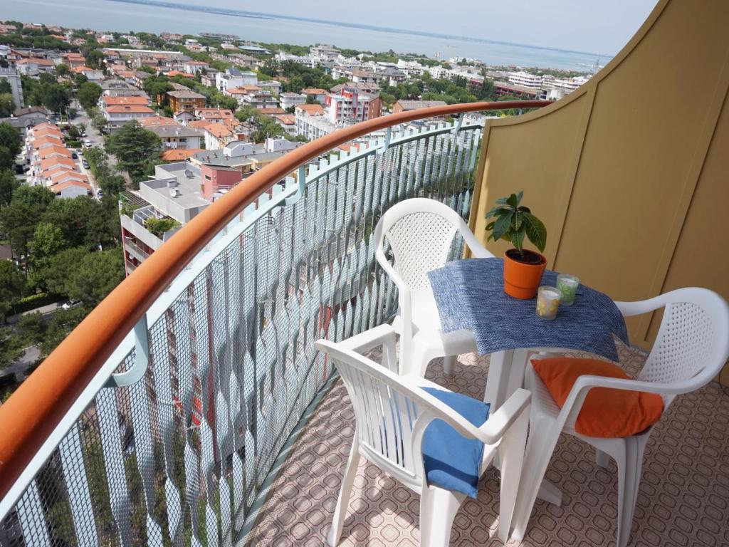 d'une table et de chaises sur un balcon avec vue. dans l'établissement Appartamenti La Torre, à Lignano Sabbiadoro