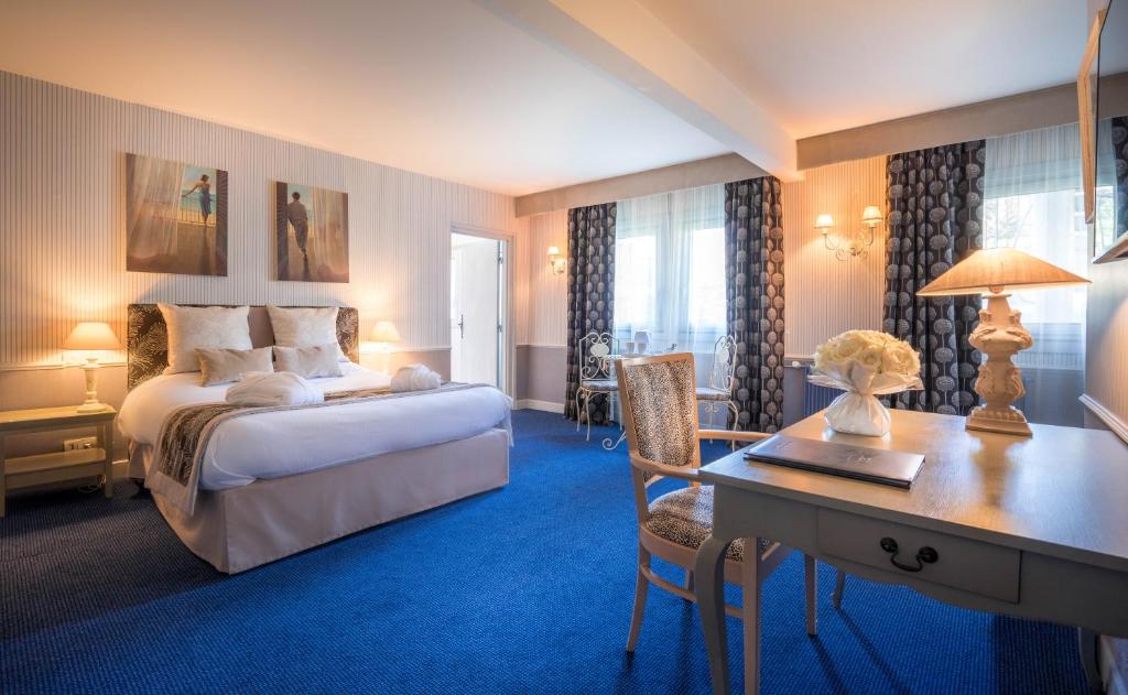 a hotel room with a bed and a desk and a desk at Best Western Plus Hostellerie Du Vallon in Trouville-sur-Mer
