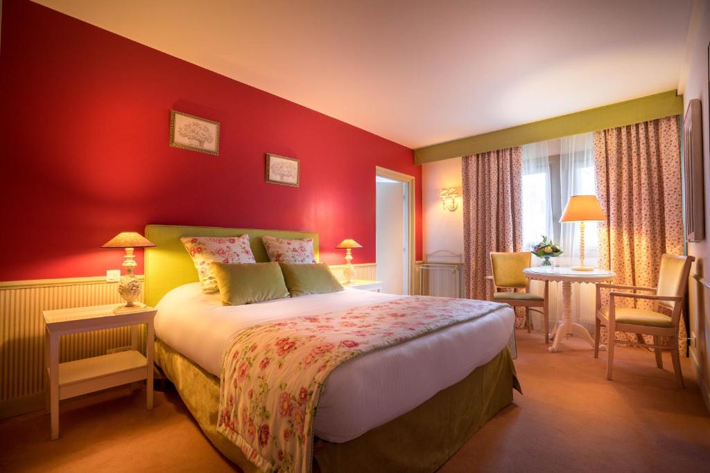 a bedroom with a bed and a red wall at Best Western Plus Hostellerie Du Vallon in Trouville-sur-Mer