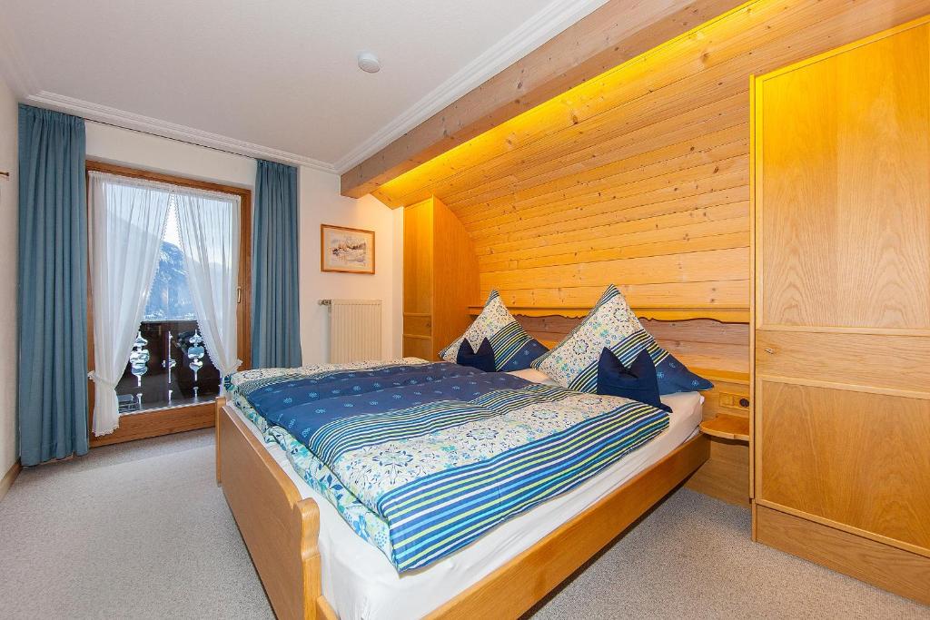 a bedroom with a large bed with a wooden headboard at Gästehaus Lipp in Mittenwald