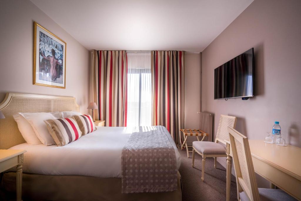 a hotel room with a bed and a window at Best Western Plus Hostellerie Du Vallon in Trouville-sur-Mer