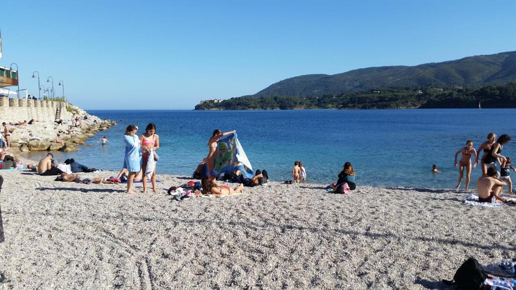un grupo de personas en una playa cerca del agua en Casa Porto Azzurro en Porto Azzurro