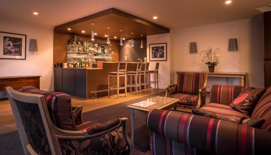 a bar in a pub with couches and a bar at Best Western Plus Hostellerie Du Vallon in Trouville-sur-Mer