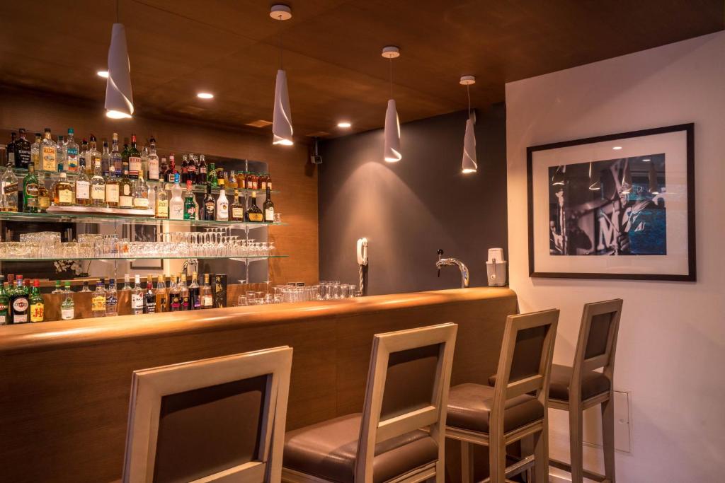 a bar with chairs and bottles of alcohol on the wall at Best Western Plus Hostellerie Du Vallon in Trouville-sur-Mer