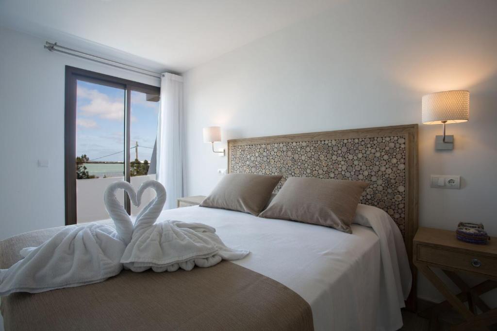 a bedroom with a bed with two white towels on it at Hotel Rosamar - Emar Hotels in Es Pujols