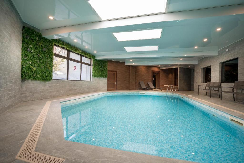 a large swimming pool in a building with a ceiling at Best Western Plus Hostellerie Du Vallon in Trouville-sur-Mer