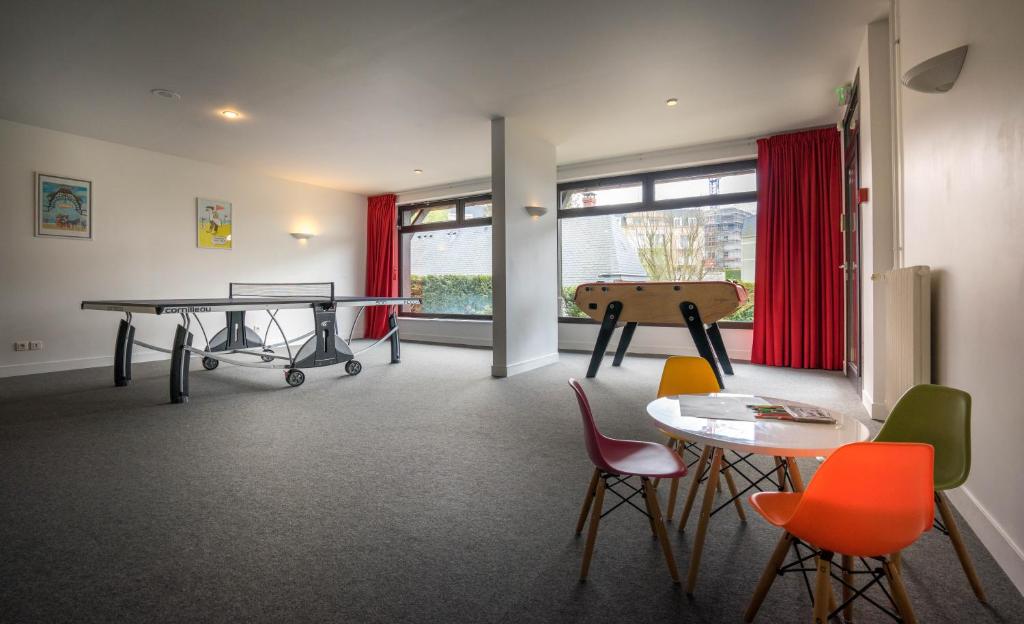 a room with a ping pong table and chairs at Best Western Plus Hostellerie Du Vallon in Trouville-sur-Mer