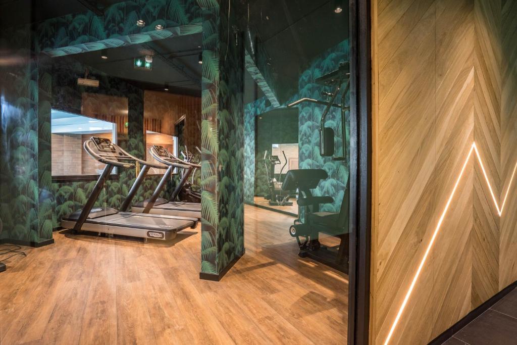 a gym with several exercise equipment in a room at Best Western Plus Hostellerie Du Vallon in Trouville-sur-Mer