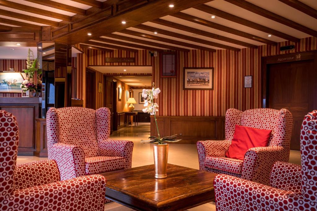 a lobby with dotted chairs and a table with a red pillow at Best Western Plus Hostellerie Du Vallon in Trouville-sur-Mer