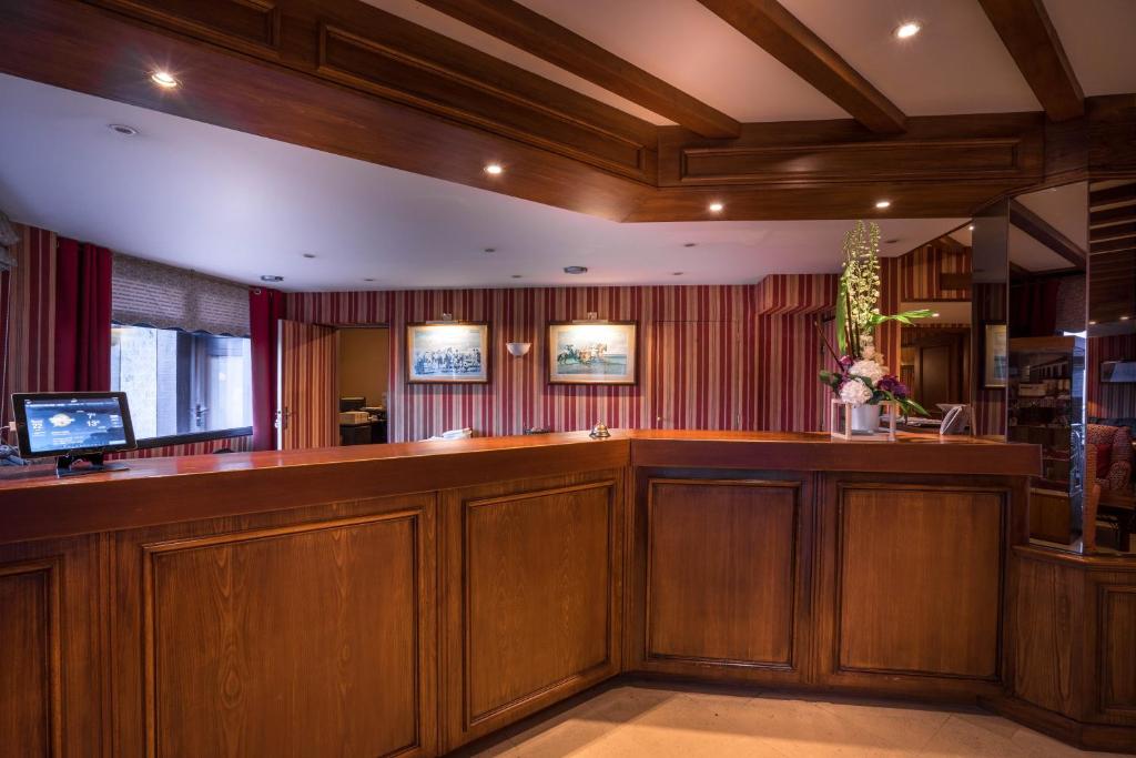 a bar in a courtroom with wood paneling at Best Western Plus Hostellerie Du Vallon in Trouville-sur-Mer