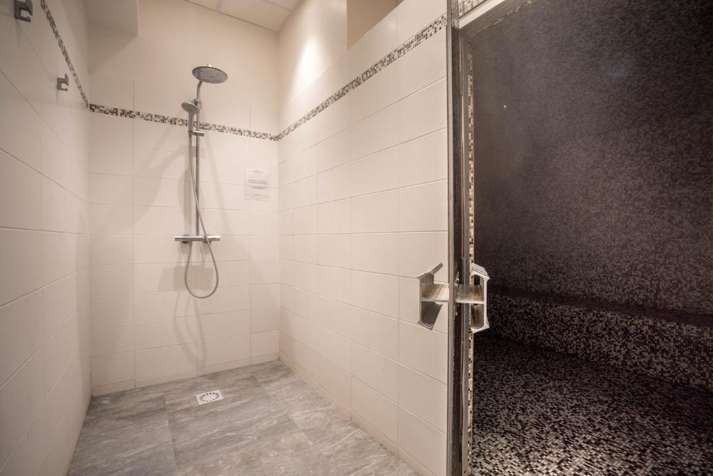 a shower stall with a door in a bathroom at Best Western Plus Hostellerie Du Vallon in Trouville-sur-Mer