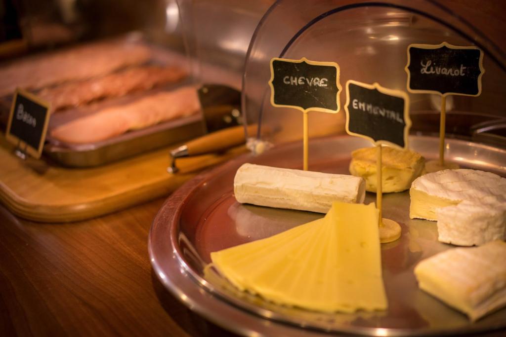 a plate of cheese and bread on a table at Best Western Plus Hostellerie Du Vallon in Trouville-sur-Mer