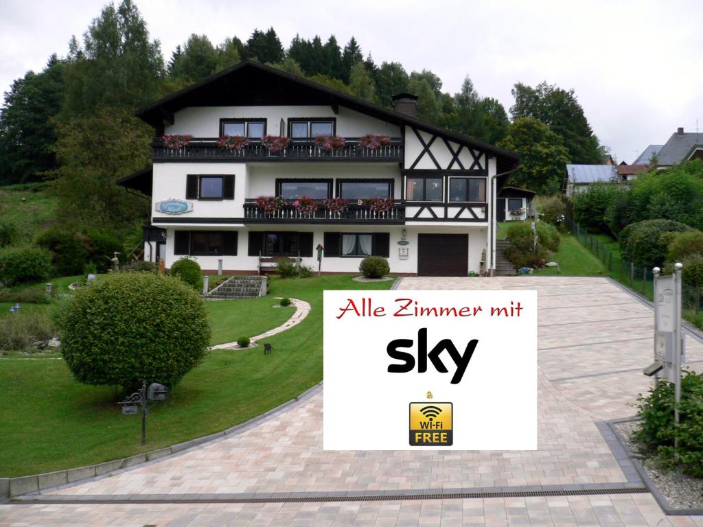 ein großes Haus mit einem Schild davor in der Unterkunft Gästehaus Riedl in Warmensteinach