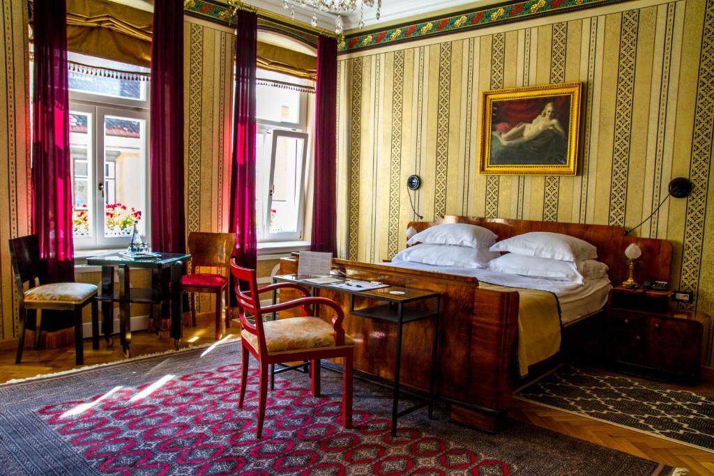 um quarto com uma cama, uma mesa e cadeiras em Vila Katharina em Braşov