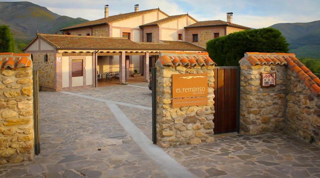 a building with a gate in front of a house at Remanso de Gredos in Navalonguilla