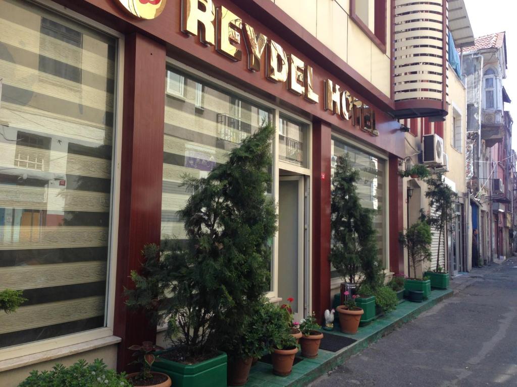 a restaurant with potted plants in front of a building at Reydel Hotel in Istanbul