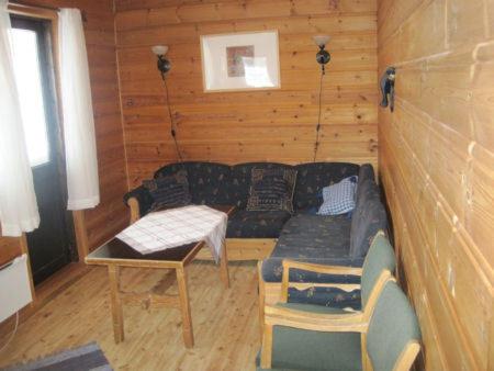 ein Wohnzimmer mit einem Sofa und einem Tisch in der Unterkunft Seljestad Cottages in Skare