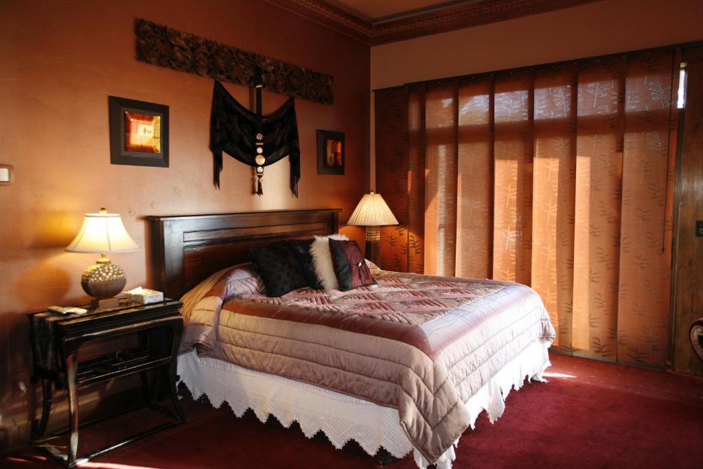 a bedroom with a bed and a table with a lamp at Swan River Inn in Bigfork