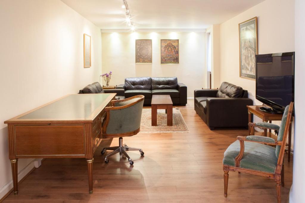 a living room with a desk and a couch at Victoria and Buckingham Palace Apartments in London