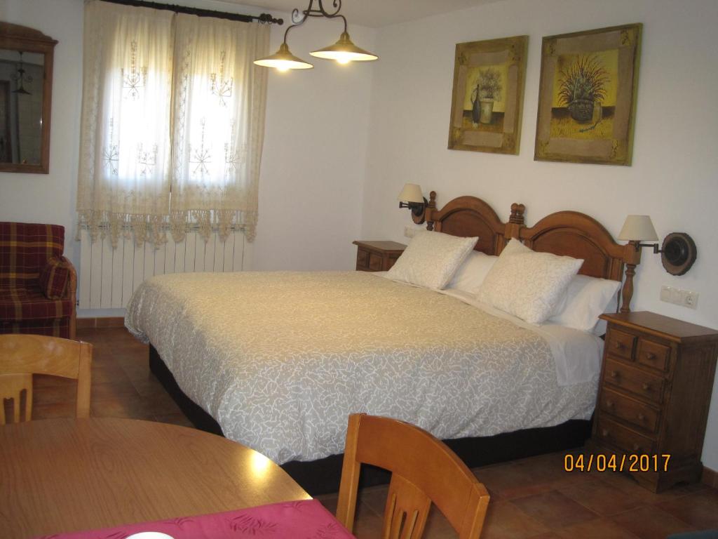 a bedroom with a large bed and a table at La Ventana De Tejera Negra in Cantalojas