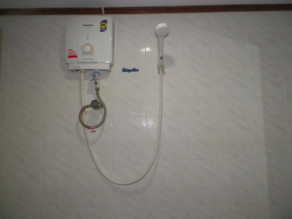 a shower in a bathroom with a hose on a wall at Natacha Hotel in Phi Phi Islands