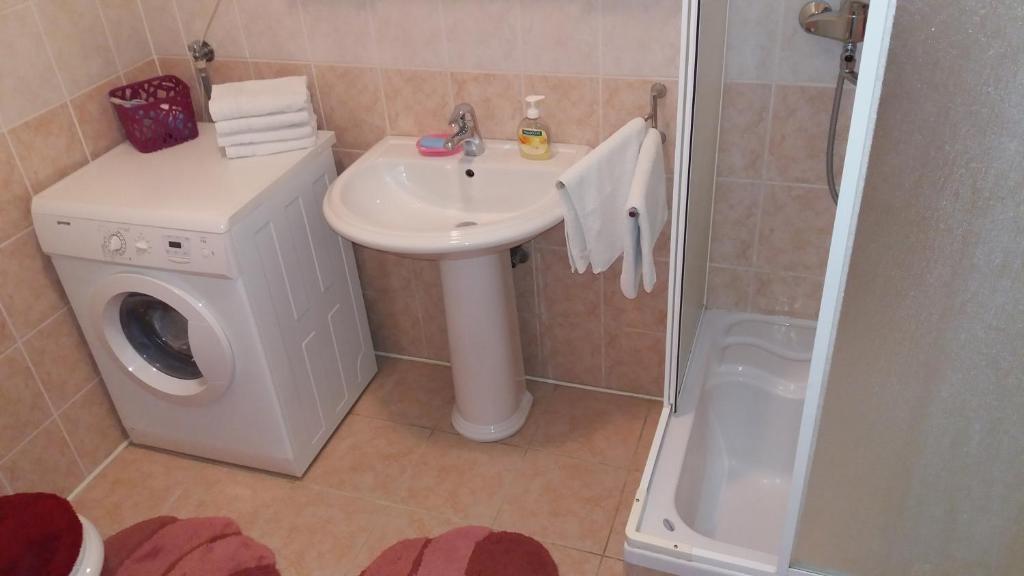 a bathroom with a sink and a washing machine at Rooms Kvestic in Dubrovnik