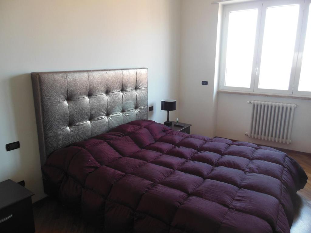トラーニにあるLa Casa degli Artistiの窓付きの客室で、大きな紫色のベッド1台を利用できます。