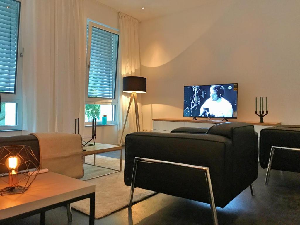 a living room with a couch and a tv at The Apartment Central in Mainz