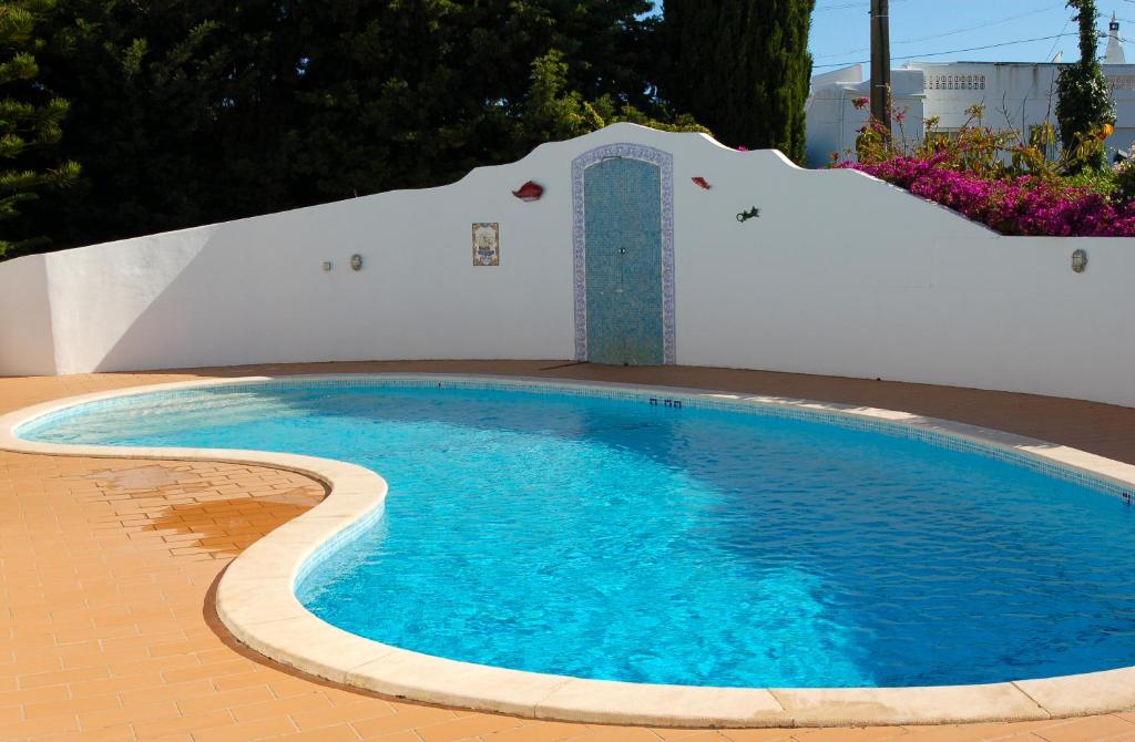 a small swimming pool with a tile floor and a building at Villa Tara Christina in Carvoeiro