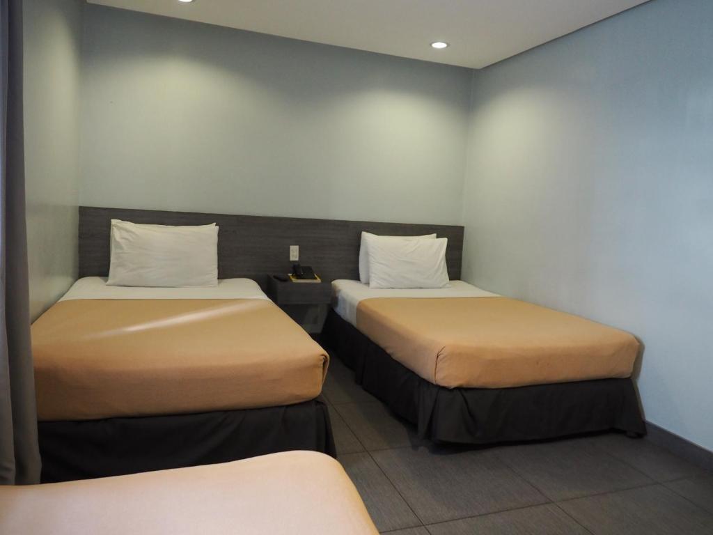 Postel nebo postele na pokoji v ubytování Cebu R Hotel Mabolo