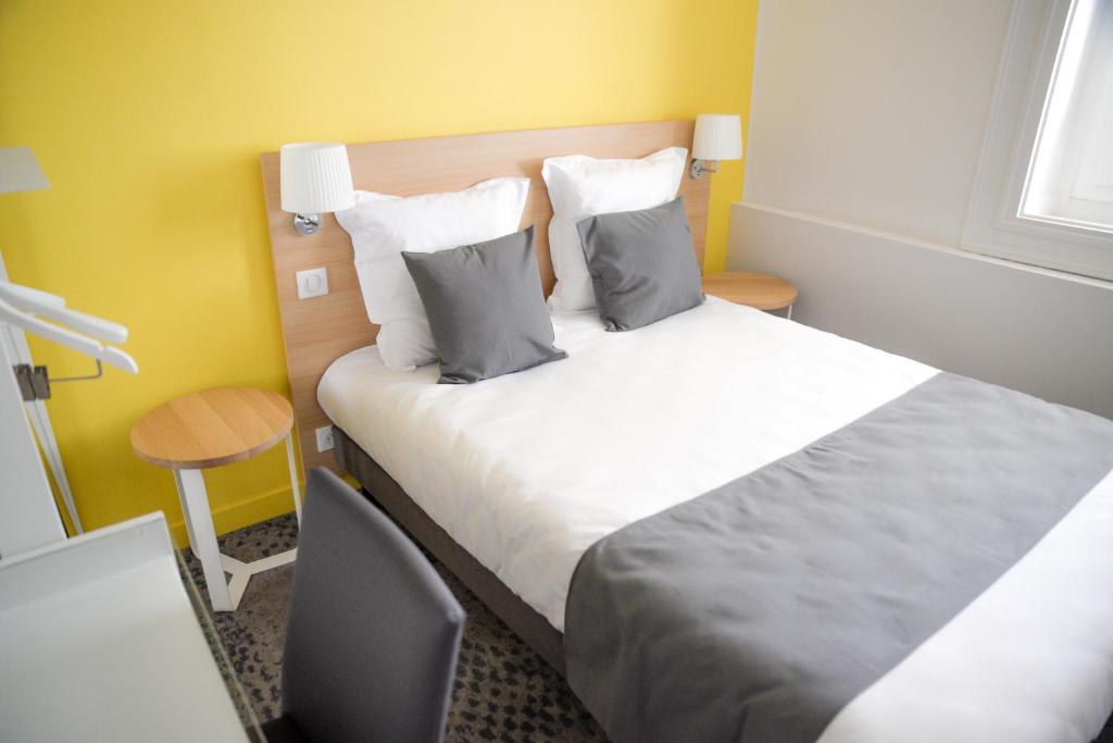 a hotel room with a bed and a desk and a bed sidx sidx at Hôtel de la Gare - Restaurant Bistro Quai in La Roche-sur-Yon