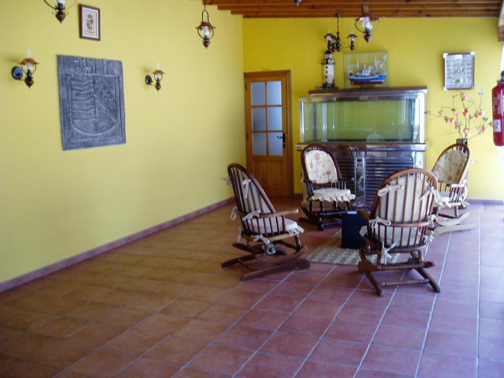 a living room with rocking chairs and a fireplace at Hospedaje El Marinero in Isla