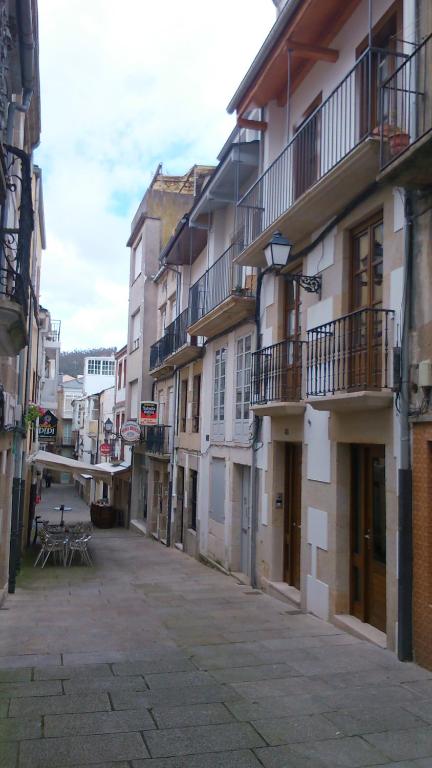 uma rua vazia numa cidade com edifícios em Apartamento con balcón em Viveiro