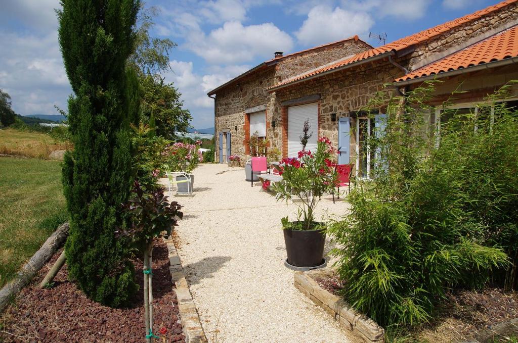 una casa de piedra con un camino que conduce a un jardín en Le Grand Noë, en Roisey