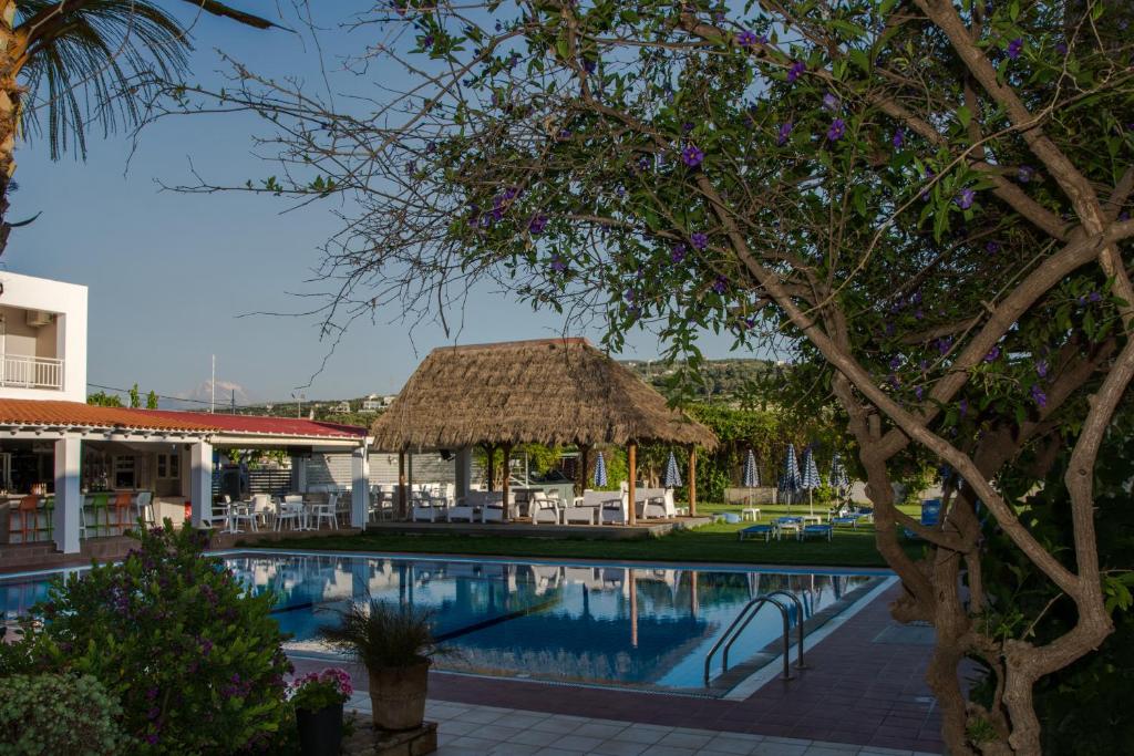 um resort com uma piscina e uma cabana de palha em Evelin Hotel em Platanes