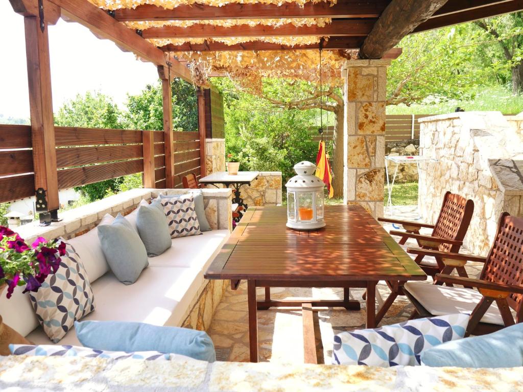 an outdoor patio with a wooden table and chairs at Villa Victoria Boutique Apartments in Sivota