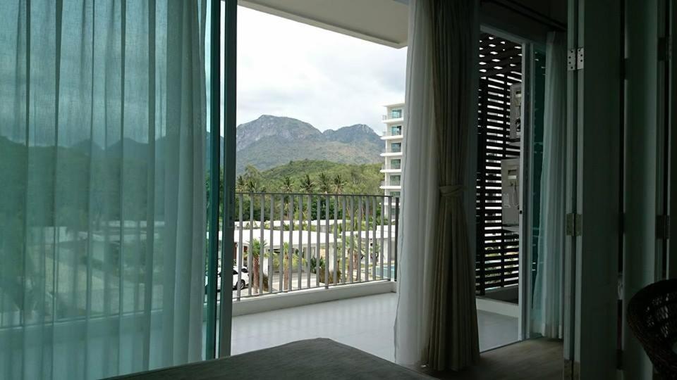 1 dormitorio con ventana grande con vistas a la montaña en The Sea B36 en Sam Roi Yot